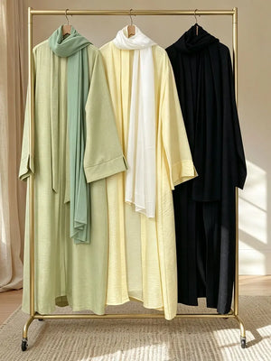 Green, Yellow and Black abayas displayed together on a clothing rail