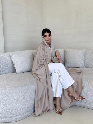 Taupe open abaya styled over white separates, seated view