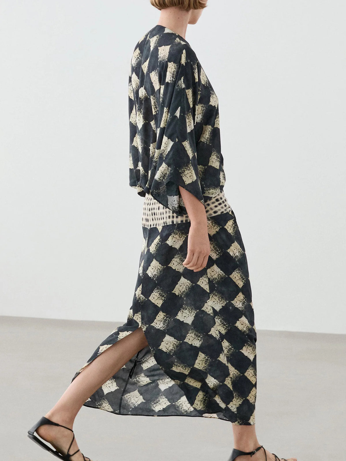 HIA diamond print twist-front dress — side view showing hem opening