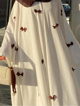 HIA Bow-Detail Flared-Sleeve Abaya — cream abaya with contrast bows