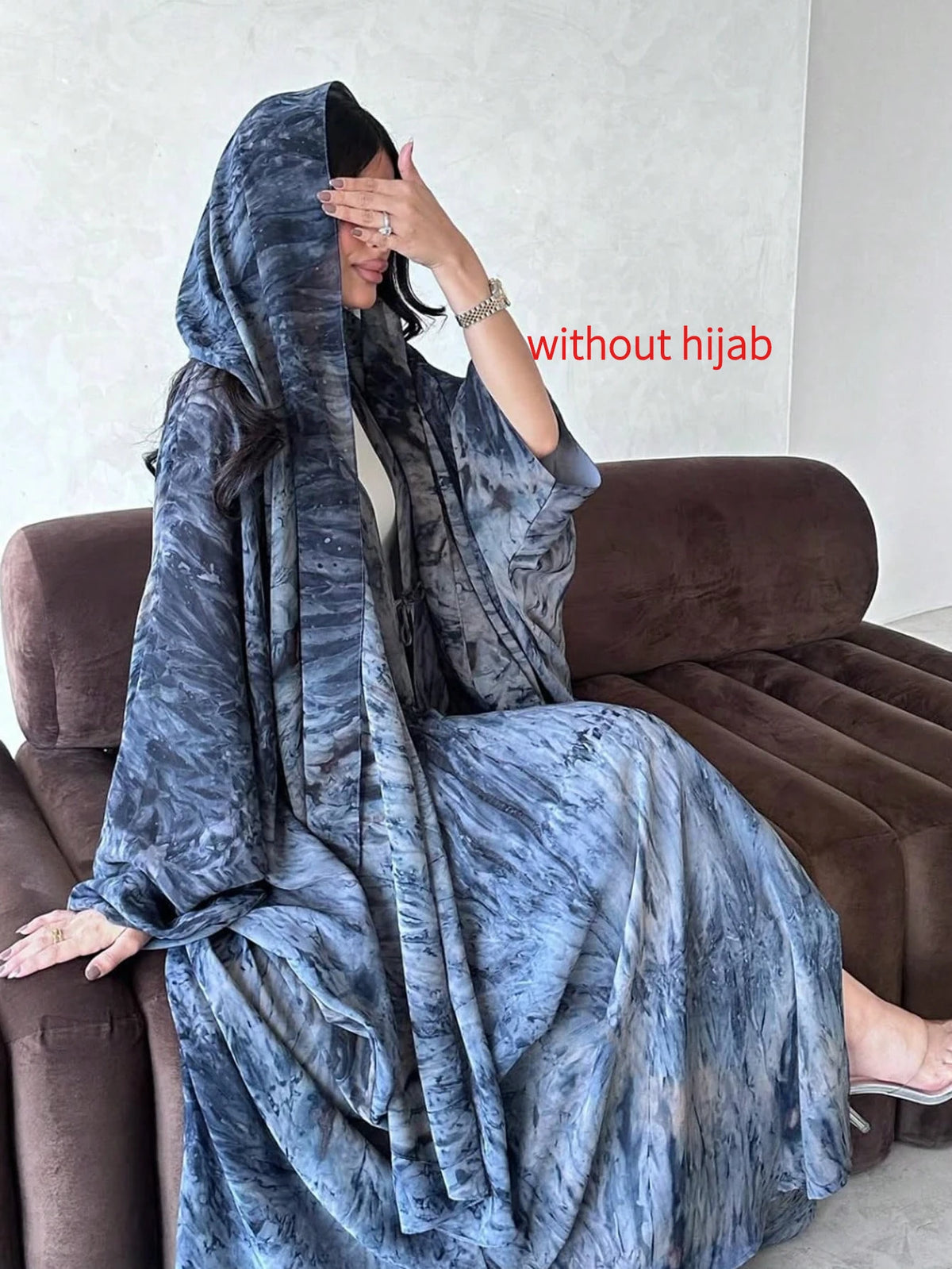 Seated view of the blue printed abaya; hijab not included