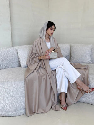 Side view of the taupe satin-look abaya while seated