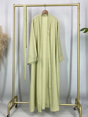 Green open abaya displayed on a hanger