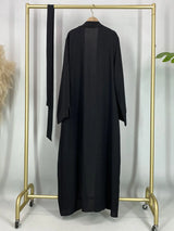 Black open abaya displayed on a hanger