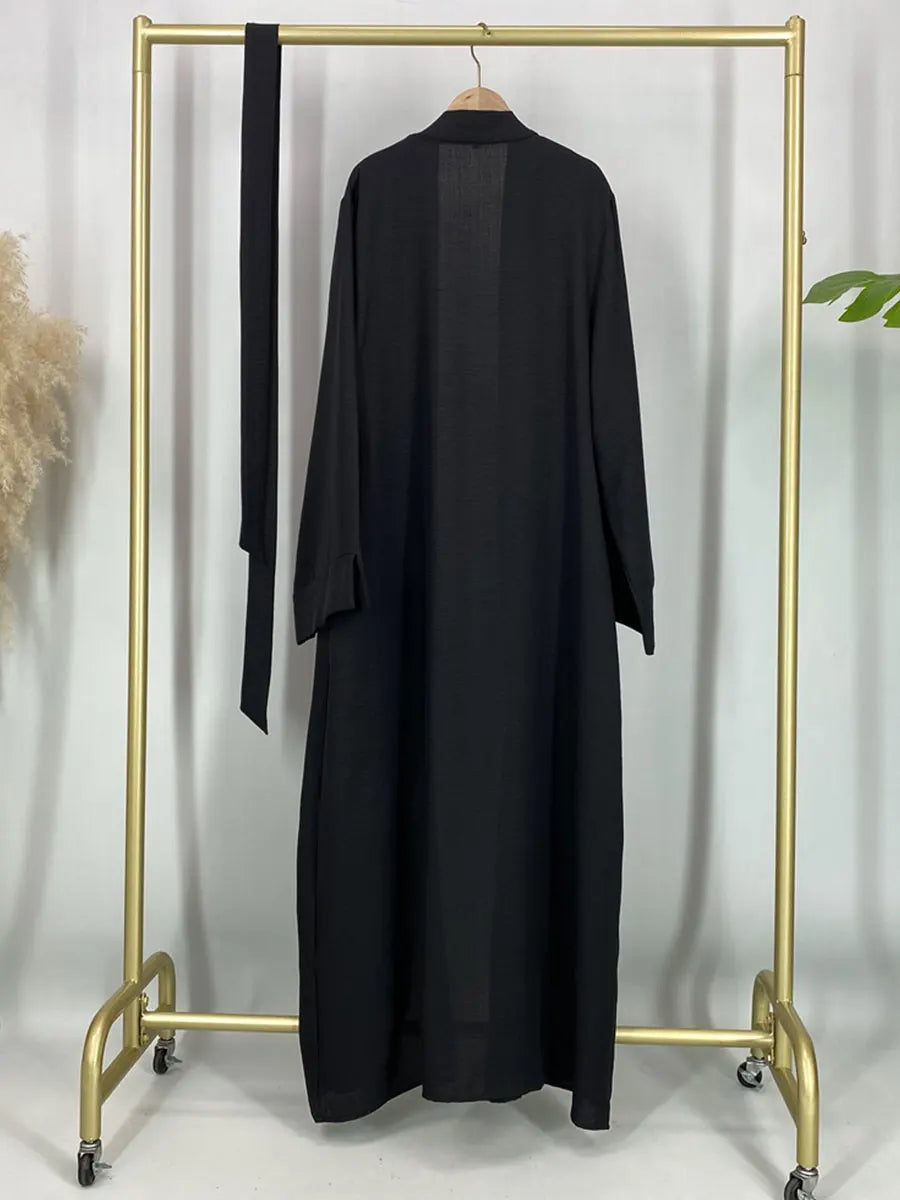 Black open abaya displayed on a hanger