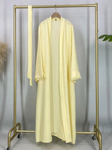 Yellow open abaya displayed on a hanger