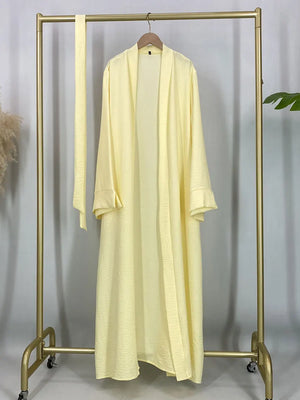 Yellow open abaya displayed on a hanger