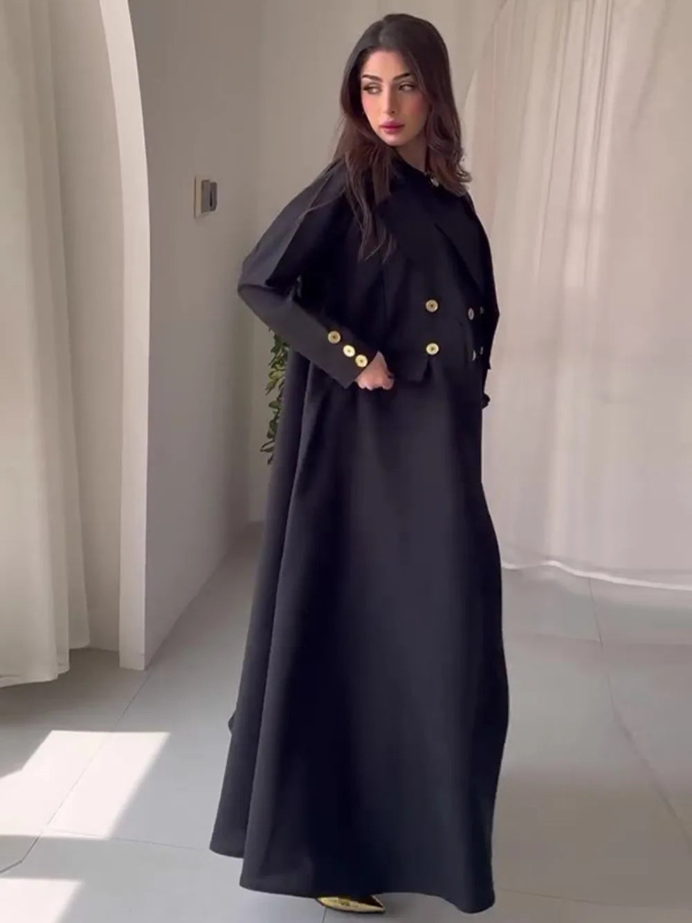 HIA black abaya with gold-tone button accents, front pose