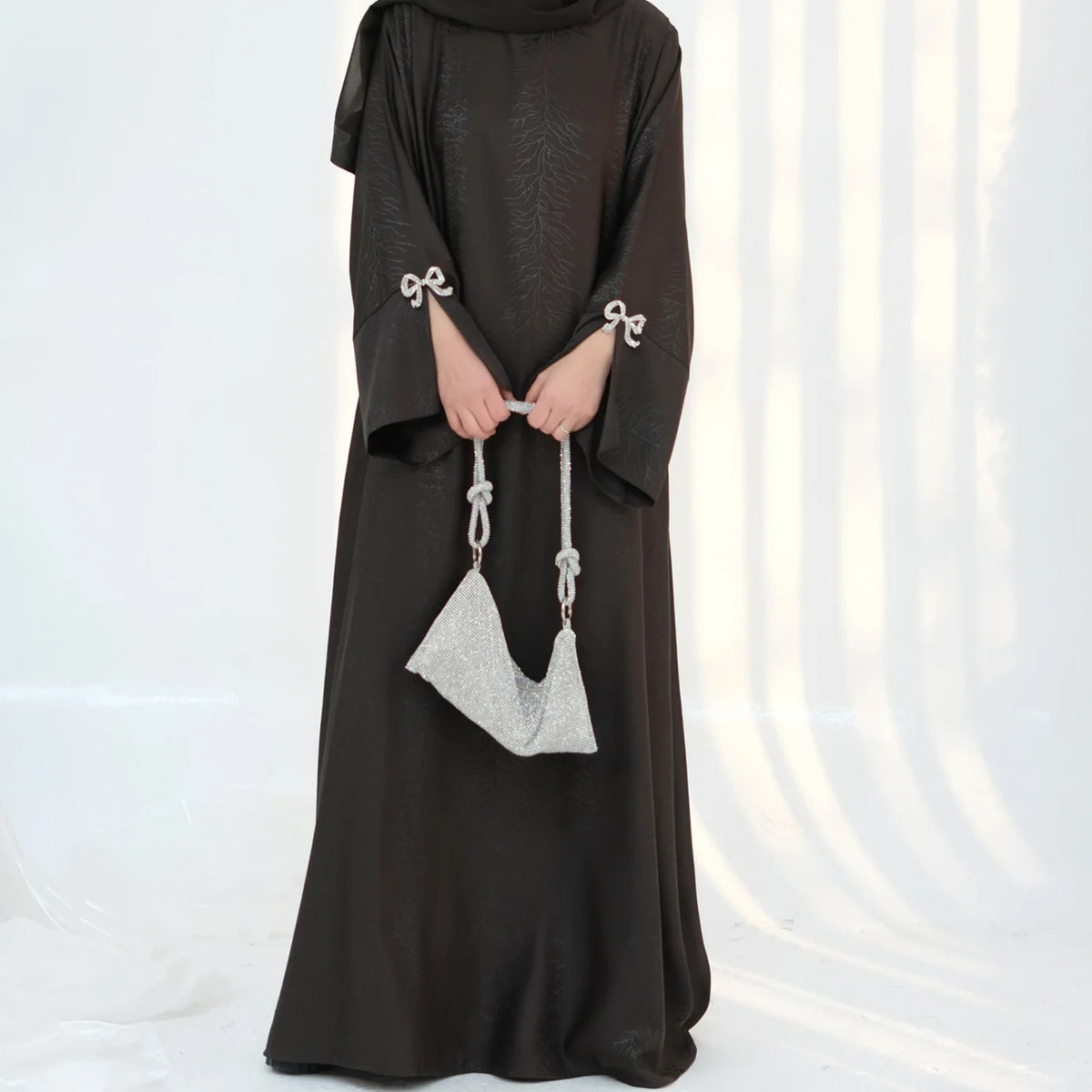 HIA Bow-Cuff Satin Abaya — Black fabric and cuff detail