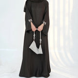 HIA Bow-Cuff Satin Abaya — Black fabric and cuff detail